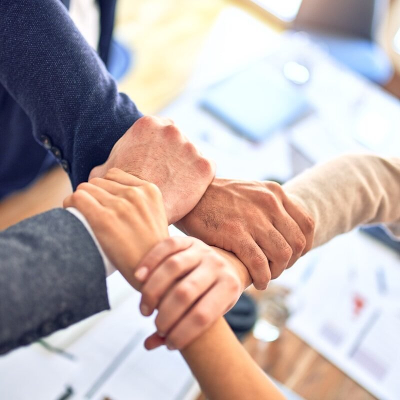 team members gripping wrists in unity gesture